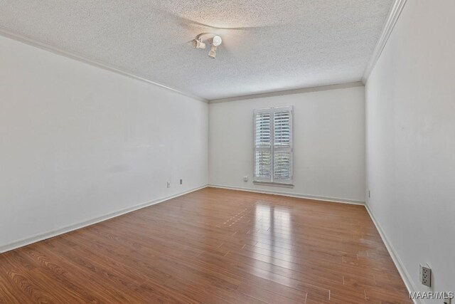 unfurnished room with ornamental molding, hardwood / wood-style floors, and a textured ceiling