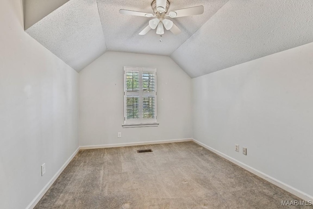 bonus room with ceiling fan, light colored carpet, lofted ceiling, and a textured ceiling