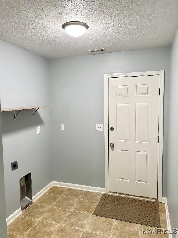 washroom featuring hookup for an electric dryer and a textured ceiling