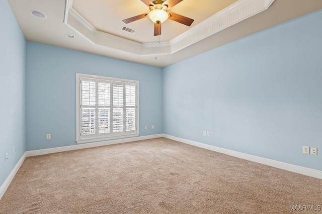 spare room with crown molding, carpet flooring, ceiling fan, and a tray ceiling