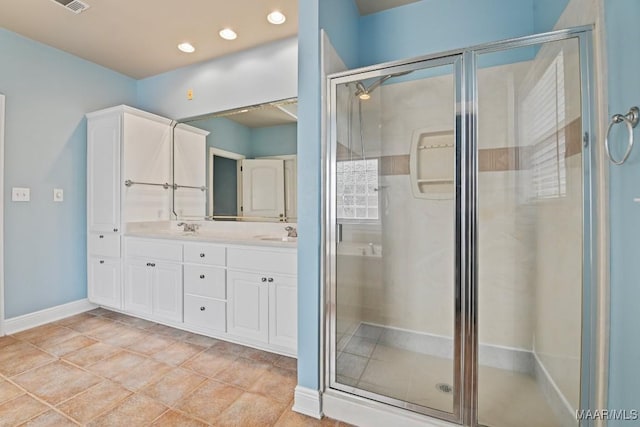 bathroom featuring vanity, tile patterned flooring, and walk in shower