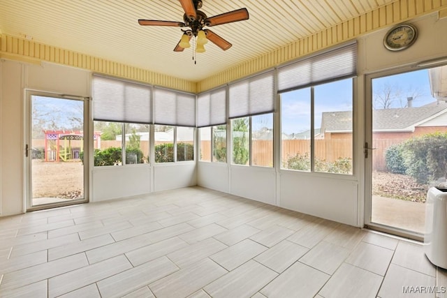 unfurnished sunroom featuring ceiling fan