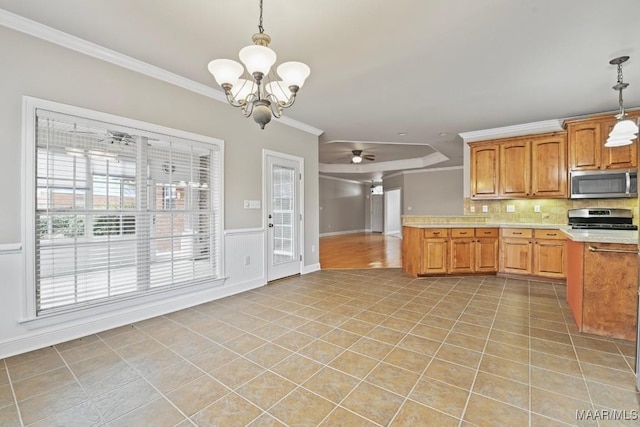 kitchen featuring ceiling fan with notable chandelier, hanging light fixtures, light tile patterned floors, stainless steel appliances, and crown molding