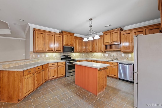 kitchen featuring appliances with stainless steel finishes, hanging light fixtures, ornamental molding, a kitchen island, and kitchen peninsula