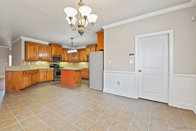 kitchen featuring appliances with stainless steel finishes, pendant lighting, ornamental molding, light tile patterned floors, and a notable chandelier