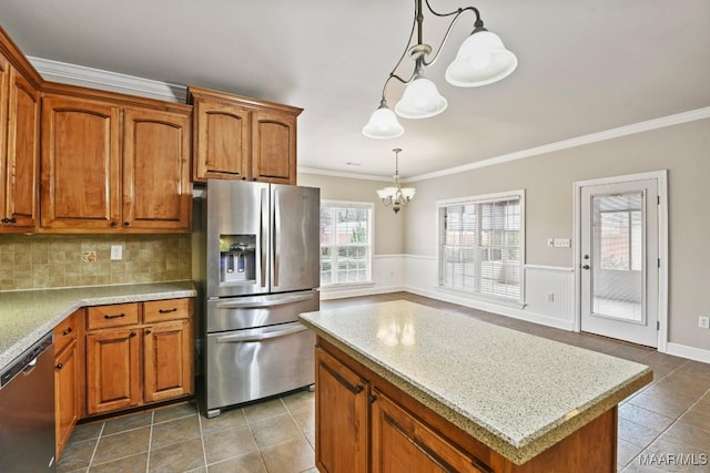 kitchen with stainless steel appliances, crown molding, a center island, and pendant lighting