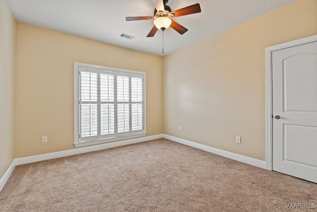 carpeted spare room featuring ceiling fan