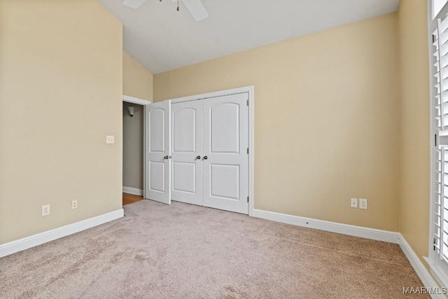 unfurnished bedroom with lofted ceiling, light colored carpet, a closet, and ceiling fan