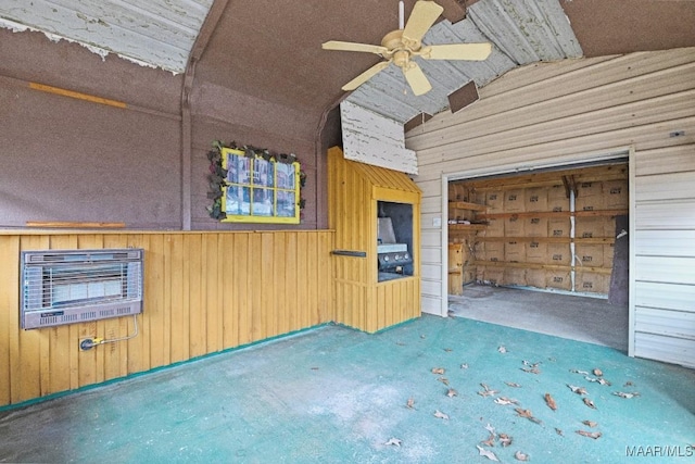 exterior space featuring ceiling fan, lofted ceiling, heating unit, and wood walls