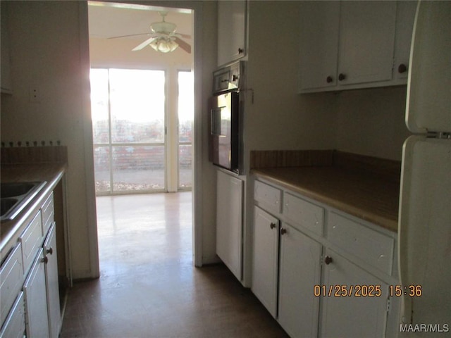 kitchen with white refrigerator, ceiling fan, oven, and white cabinets