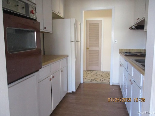 kitchen featuring white fridge, sink, white cabinets, and dark hardwood / wood-style flooring