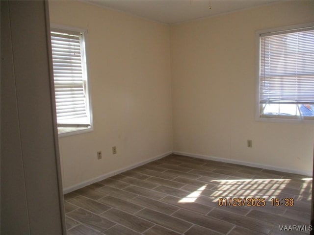 spare room featuring plenty of natural light and dark hardwood / wood-style floors