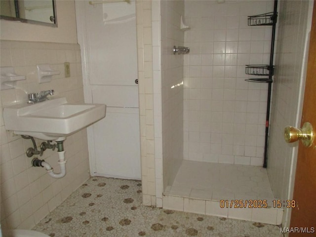 bathroom featuring tiled shower, tile walls, and backsplash