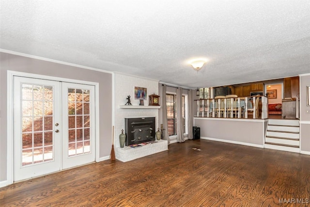 unfurnished living room with crown molding, dark wood-type flooring, french doors, and a textured ceiling