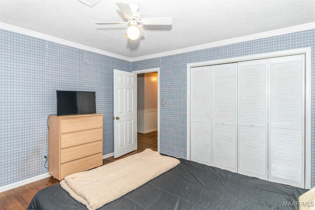 bedroom with crown molding, a closet, ceiling fan, and hardwood / wood-style flooring