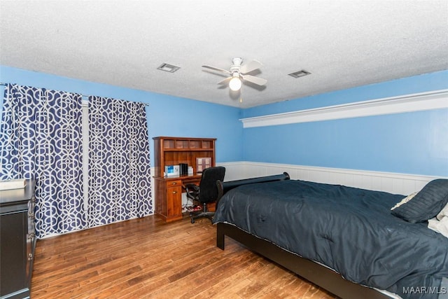 bedroom featuring hardwood / wood-style flooring, a textured ceiling, and ceiling fan