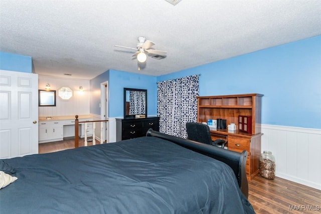 bedroom with ceiling fan, dark hardwood / wood-style flooring, and a textured ceiling