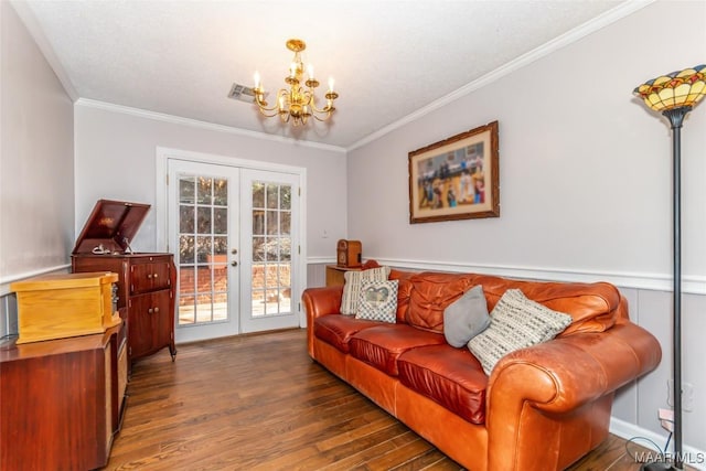 living room with french doors, ornamental molding, dark wood-type flooring, and a notable chandelier