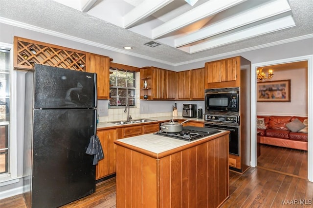 kitchen featuring crown molding, a center island, sink, and black appliances