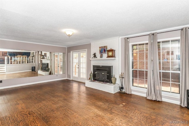 unfurnished living room with dark wood-type flooring, french doors, and a textured ceiling