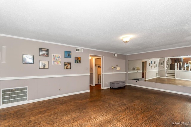 empty room with crown molding, a textured ceiling, and dark hardwood / wood-style flooring