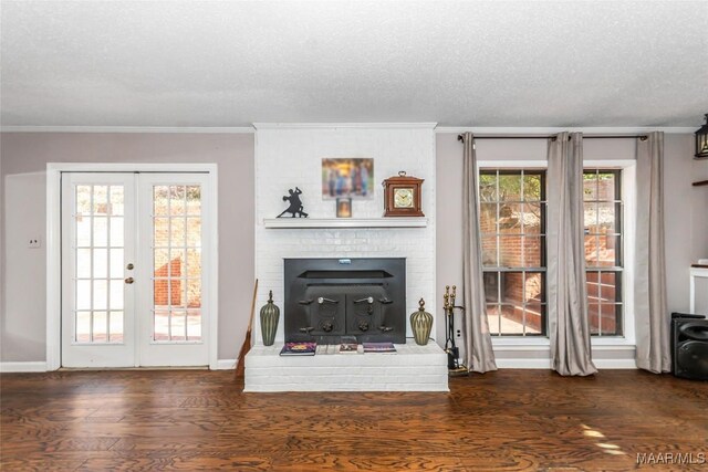 unfurnished living room with french doors, ornamental molding, dark wood-type flooring, and a textured ceiling