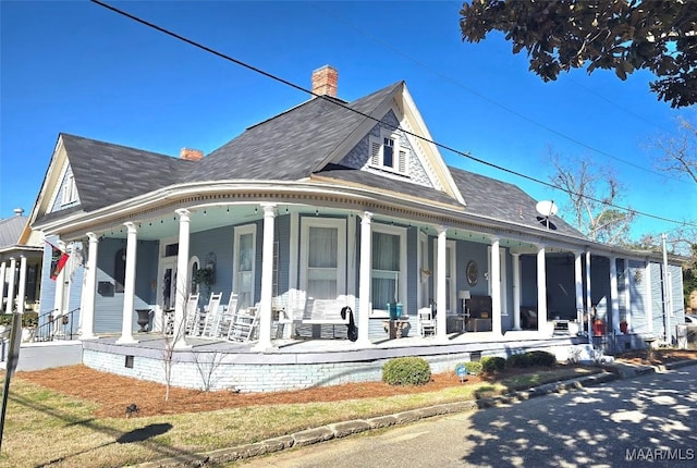 rear view of property featuring a porch