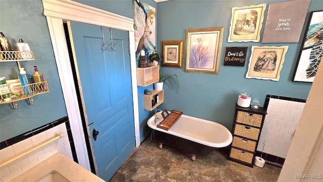 bathroom with tile walls, vanity, and a bathtub