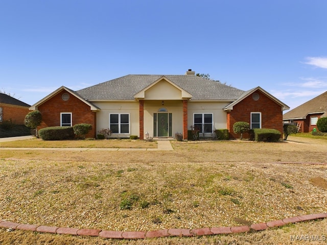 single story home with a shingled roof, a chimney, and a front yard