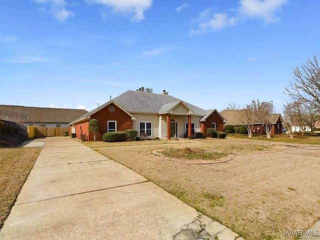 ranch-style house with concrete driveway, roof with shingles, and fence