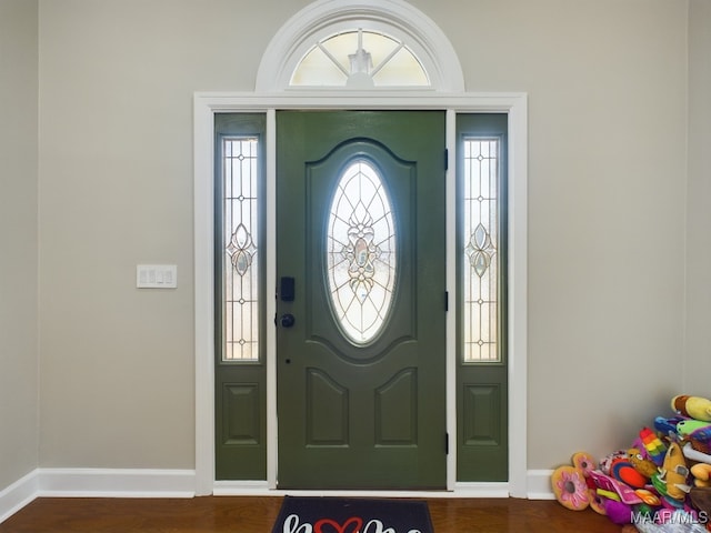 entryway with a healthy amount of sunlight, baseboards, and dark wood finished floors