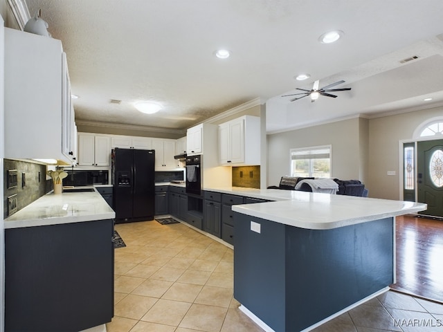 kitchen with black appliances, a peninsula, light countertops, and white cabinetry