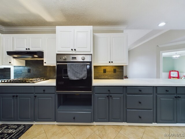 kitchen with wall oven, under cabinet range hood, stainless steel gas cooktop, white cabinetry, and light countertops