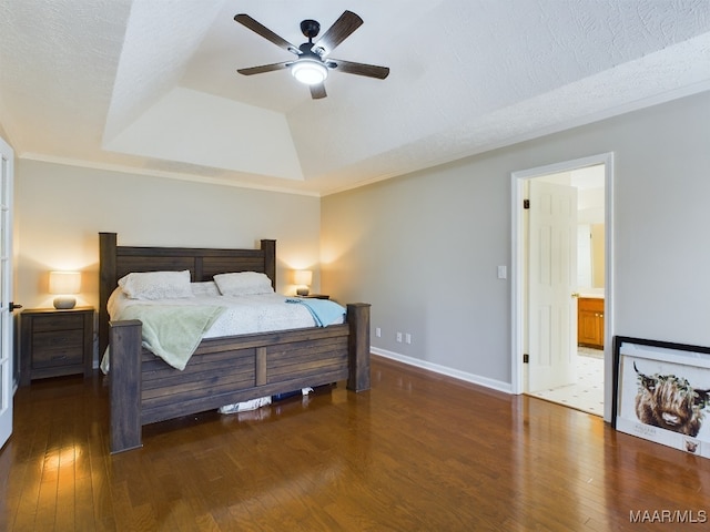 bedroom featuring dark wood-style floors, a raised ceiling, a ceiling fan, a textured ceiling, and baseboards