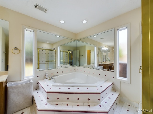 bathroom featuring visible vents, vanity, a bath, tile patterned floors, and a stall shower