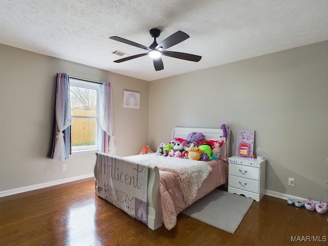 bedroom featuring dark wood-style floors, a textured ceiling, visible vents, and baseboards