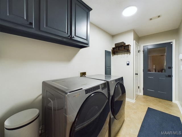 laundry room with washing machine and clothes dryer, light tile patterned floors, visible vents, cabinet space, and baseboards