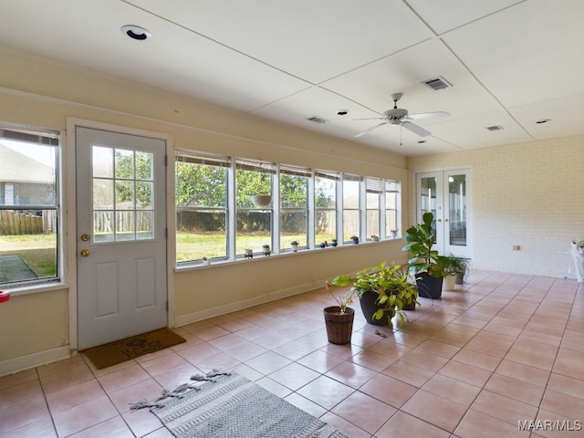 unfurnished sunroom with visible vents and ceiling fan