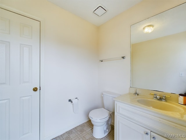 bathroom with baseboards, vanity, and toilet