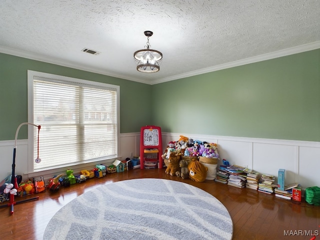 playroom featuring a chandelier, dark wood-type flooring, wainscoting, and visible vents