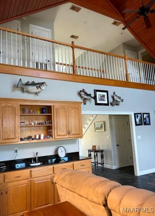 interior space featuring ceiling fan, sink, and high vaulted ceiling