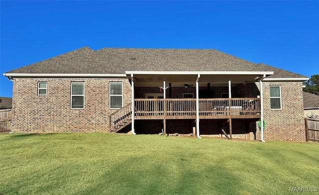 rear view of house with a wooden deck and a lawn