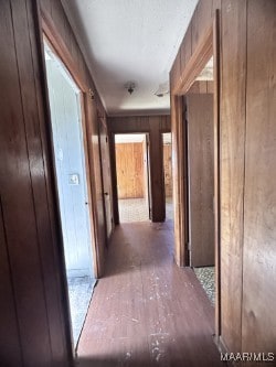 hallway with hardwood / wood-style floors and wooden walls