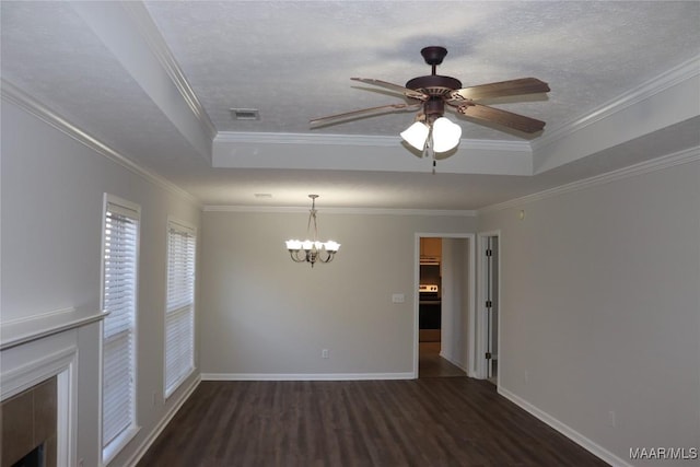 empty room with ceiling fan with notable chandelier, ornamental molding, a tray ceiling, dark wood-type flooring, and a textured ceiling