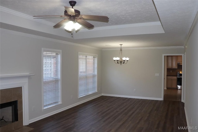 unfurnished living room with a tiled fireplace, ornamental molding, a tray ceiling, dark wood-type flooring, and a textured ceiling