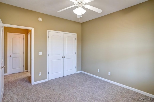 unfurnished bedroom featuring light colored carpet, a closet, and ceiling fan