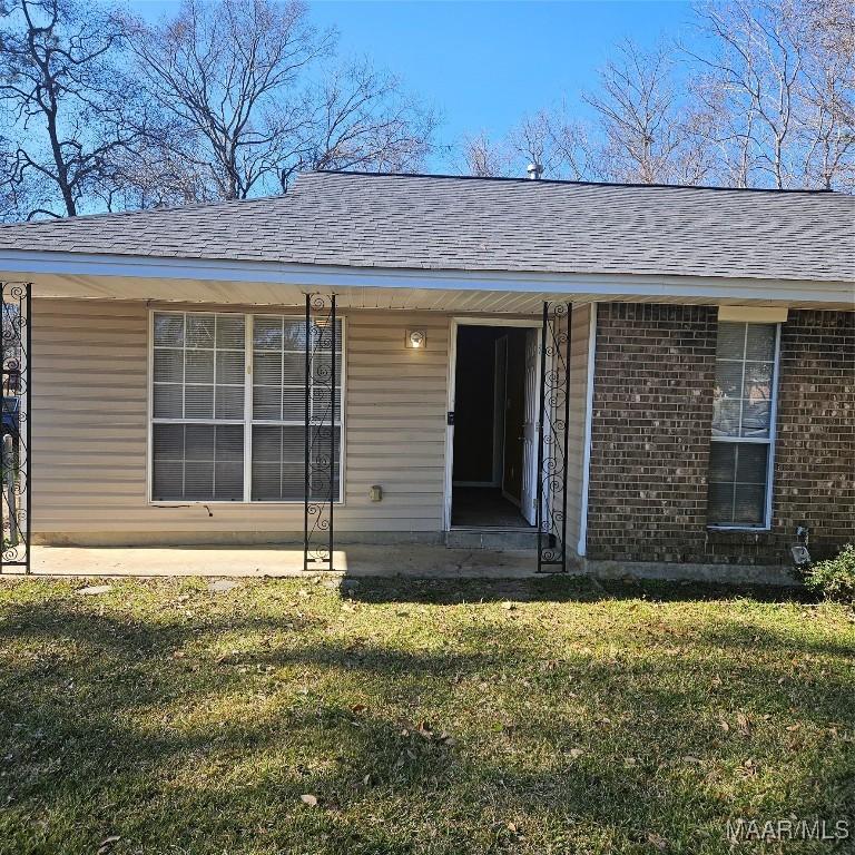 entrance to property with a lawn