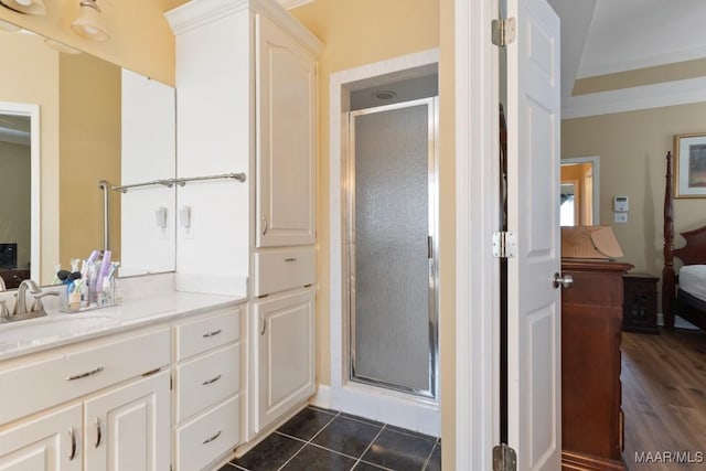 bathroom featuring crown molding, tile patterned floors, a shower with shower door, and vanity