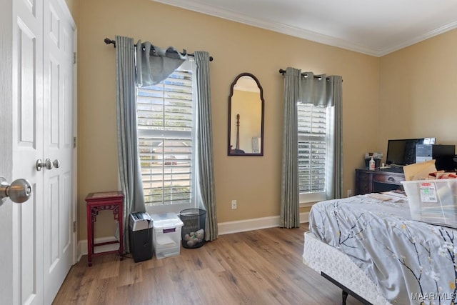 bedroom featuring crown molding, wood-type flooring, and a closet