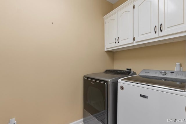 washroom featuring cabinets and washer and clothes dryer